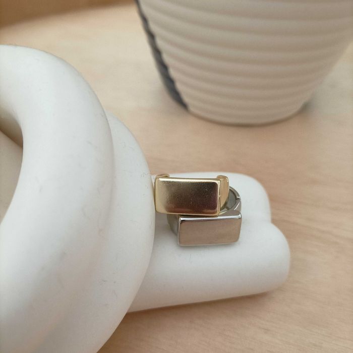 Conjunto de anéis em aço, um dourado e outro prateado.