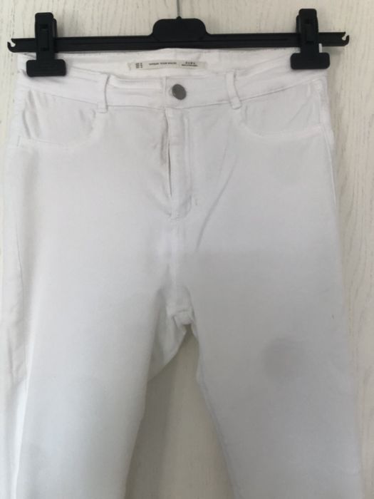 Białe spodnie z przetarciami jeans zara