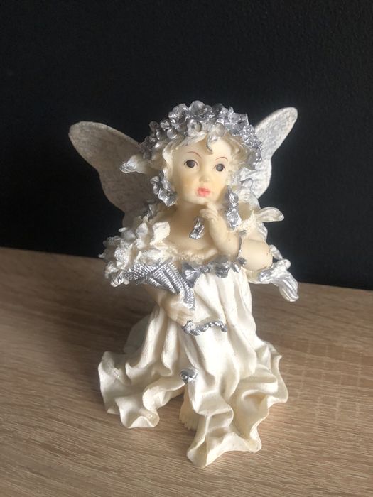 Figurka z żywicy Aniołek z różą i koszem kwiatów w ręku.