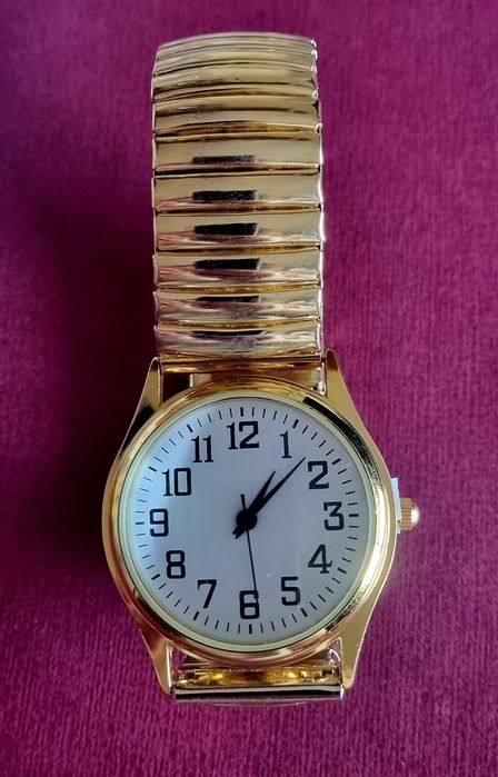 Relógio dourado, elástico, com mostrador em aço.