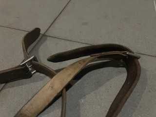 Um par de estribos metálicos com suspensões em couro