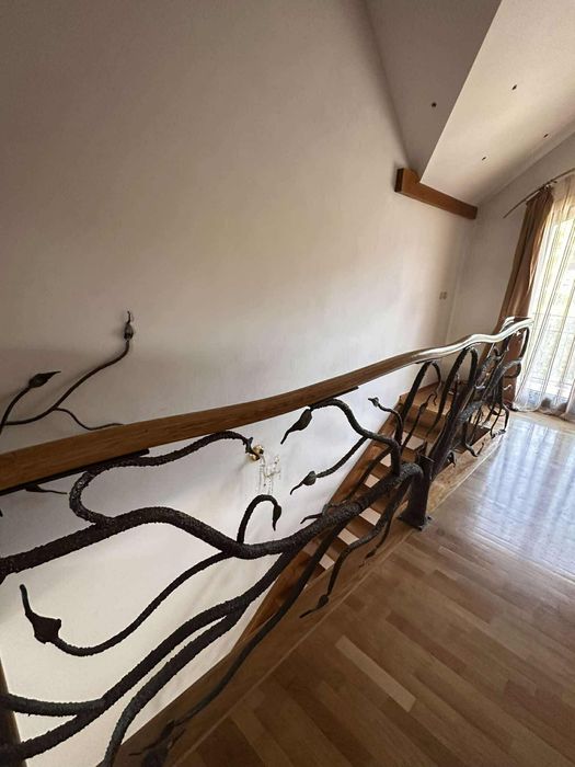 Piękne dębowe schody z kuta barierka i giętą poręczą