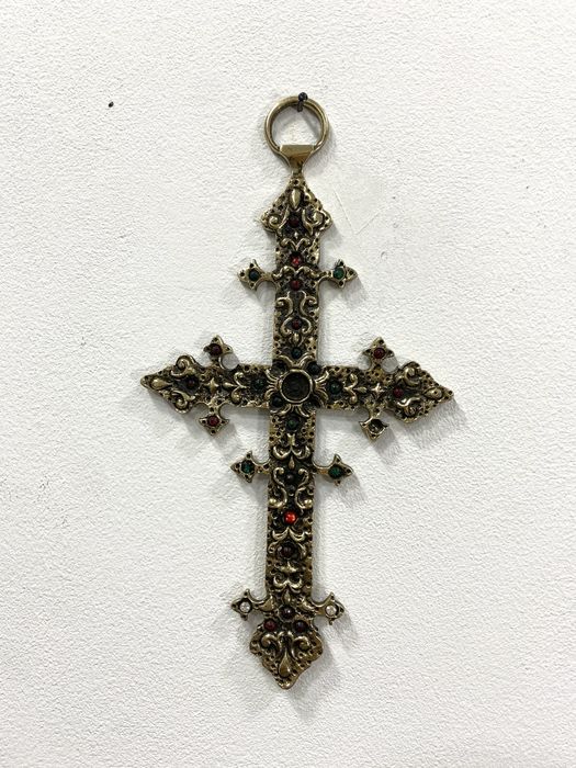 Cruz em metal dourado.