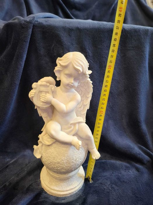 Querubim (anjo-bebé) sentado numa bola em Marfinite