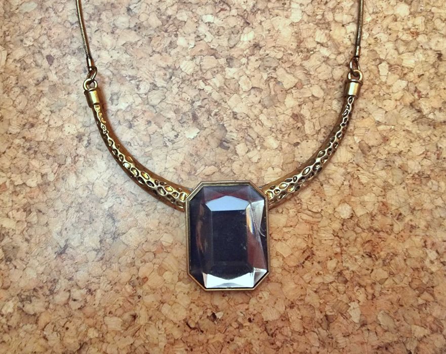 Colar dourado com uma pedra