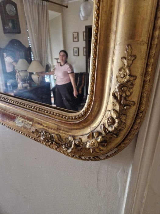 Grande espelho de parede antigo, com uma moldura dourada ornamentada de estilo clássico