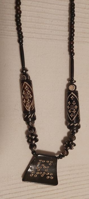 Vários colares de praia feitos de sementes polidas e outros materiais