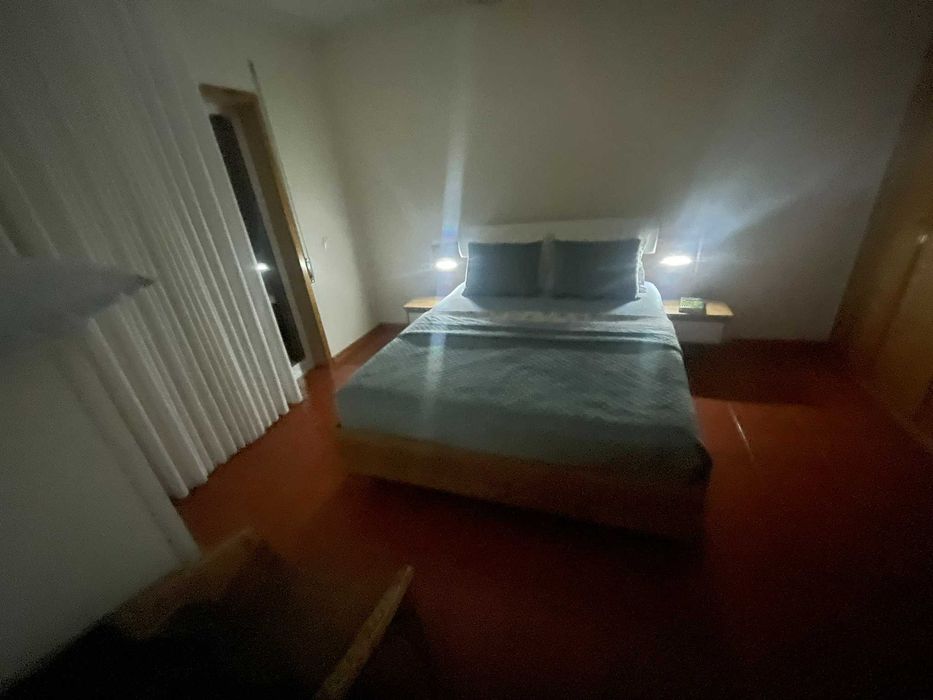 Cama de casal com mesas de cabeceira e iluminação
