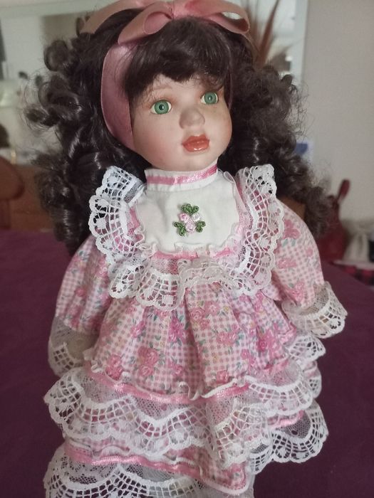 Linda boneca com o rosto em porcelana