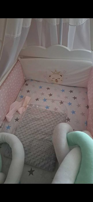 Solidne, białe łóżeczko dziecięce z baldachem.