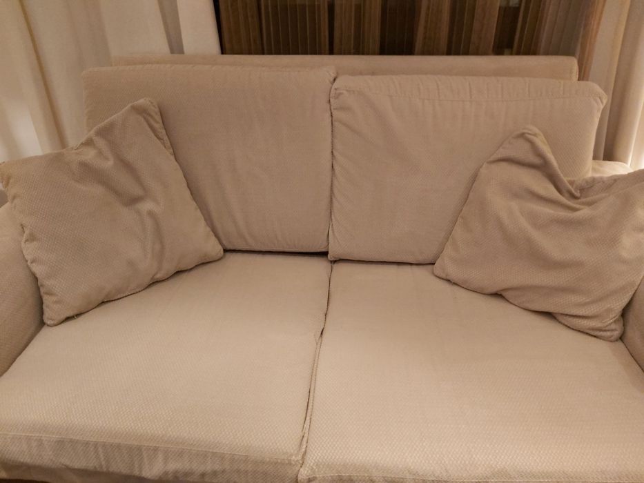 Sofá de 2 lugares com pés de madeira.