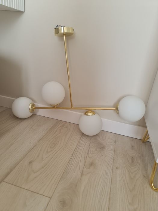 Zlota lampa sufitowa z bialymi kloszami