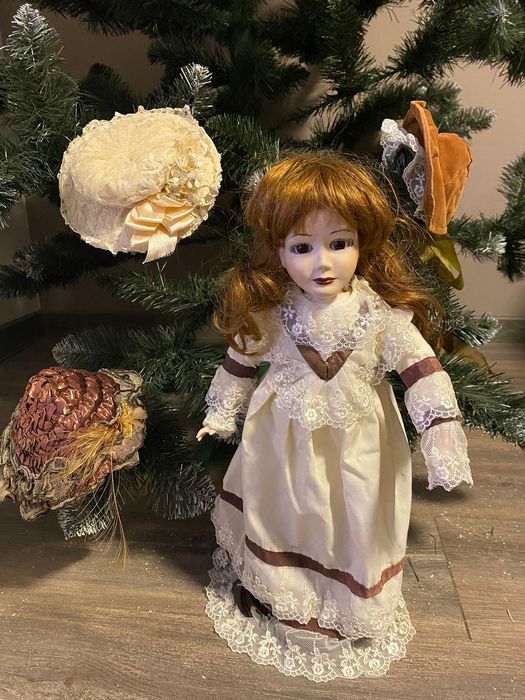 Фарфорова лялька зі змінними капелюшками.