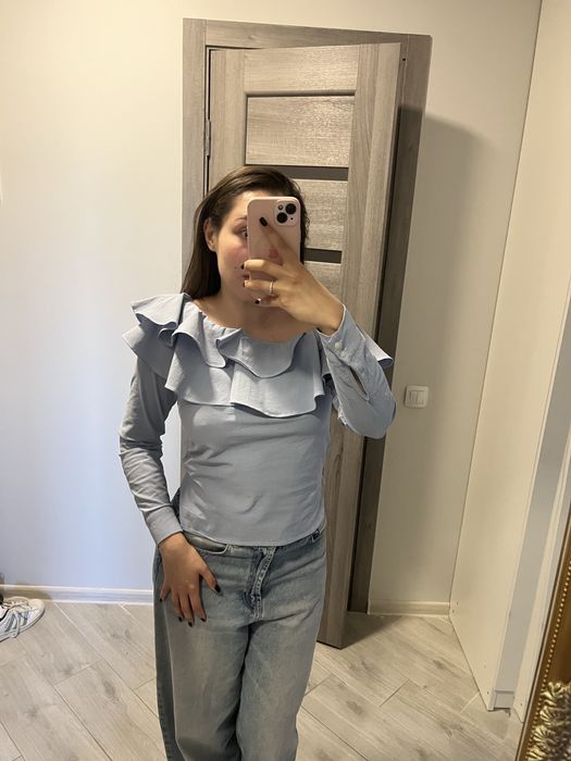 Блакитна блуза з оголеним плечем і обʼємним воланом