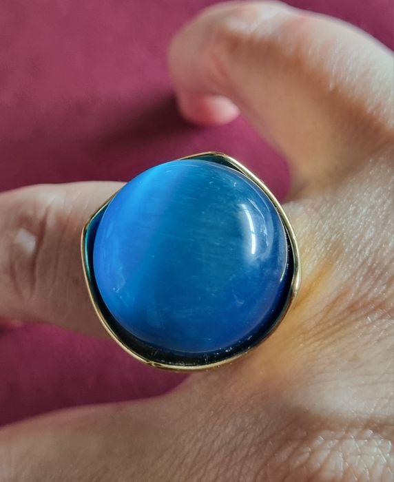 Anel dourado, em aço, com grande pedra azulão. T17
