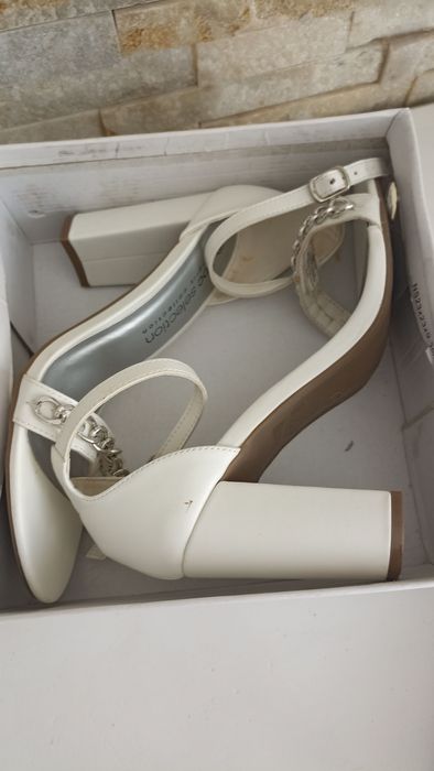 Białe sandały na slupku