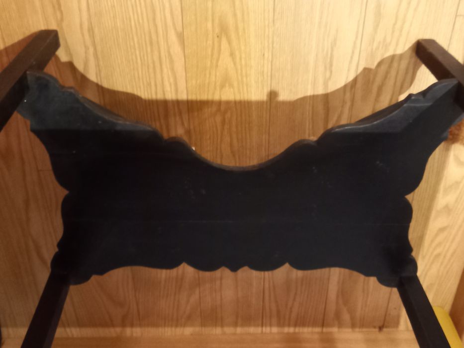 Mesa de apoio preta, antiga. Tem 2 abas pequenas e uma gaveta.