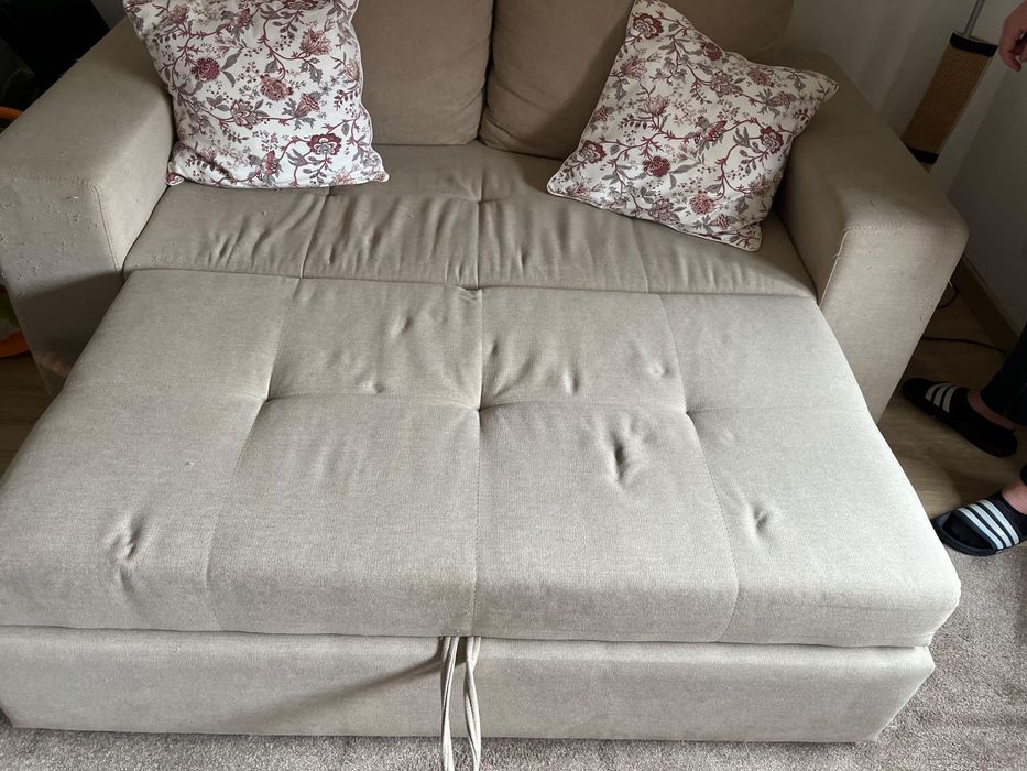 Sofá cama de dois lugares com marcas de uso