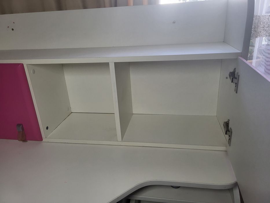 кутовий письмовий стіл для школяра з біло-рожевою надбудовою.