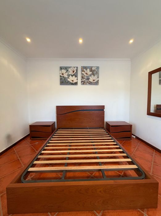 Uma cama com 2 mesinhas de cabeceiras e uma cómoda