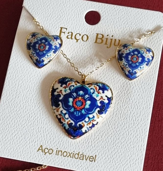 Conjunto dourado, em aço, com corações de Viana em tons de azul.