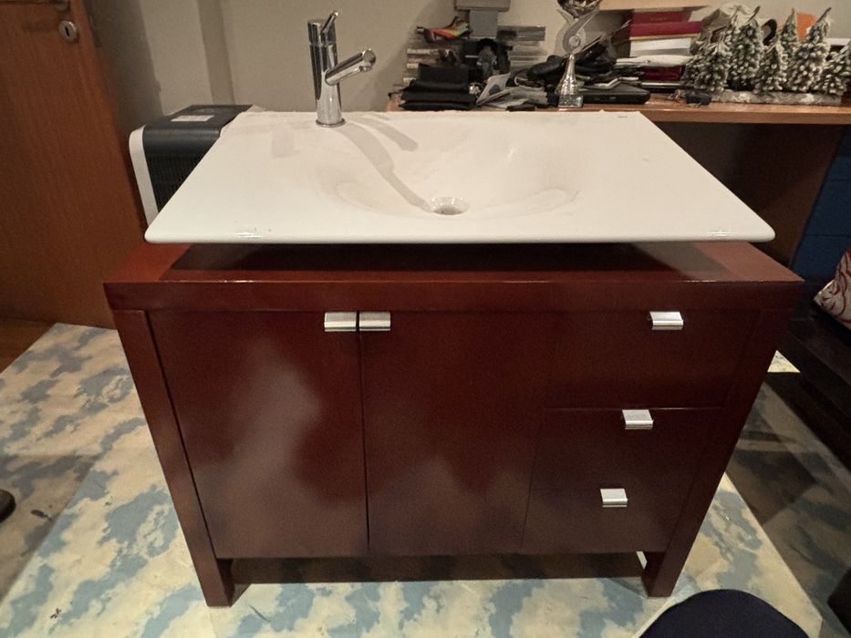 Movel de casa de banho com lavatorio e torneira.