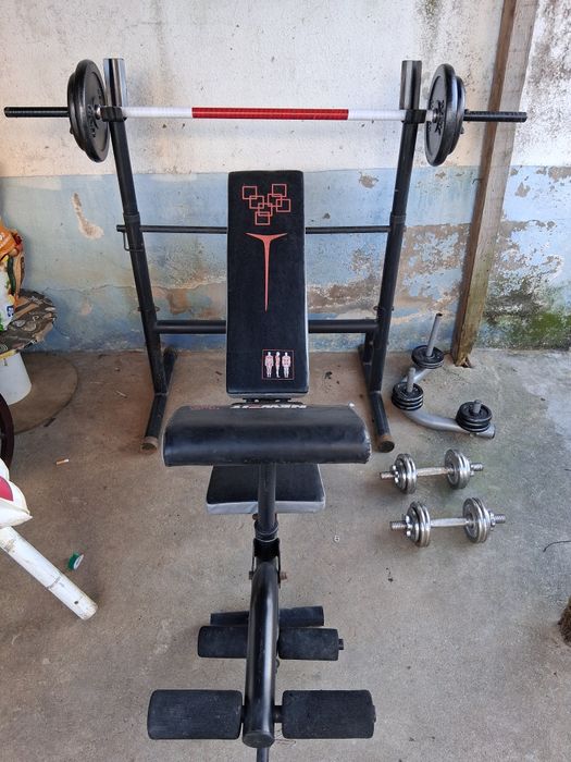 Banco de ginásio e muitos pesos