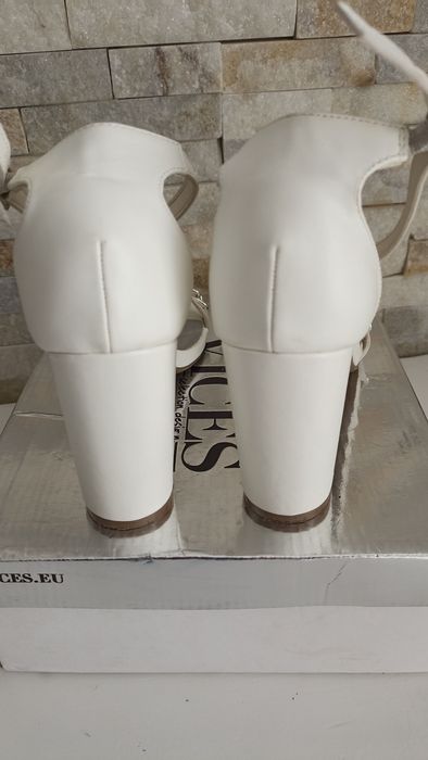 Białe sandały na slupku