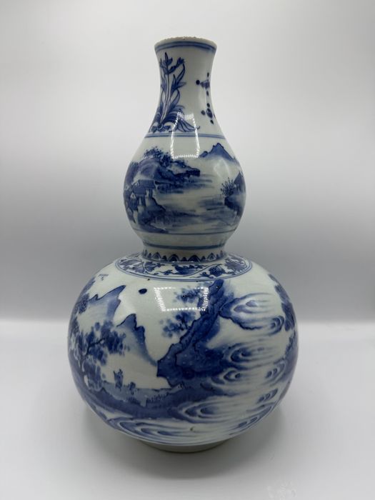 Jarra em porcelana chinesa de duplo cabaça, em azul e branco, com cena de paisagem montanhosa, século XIX, 32 cm.