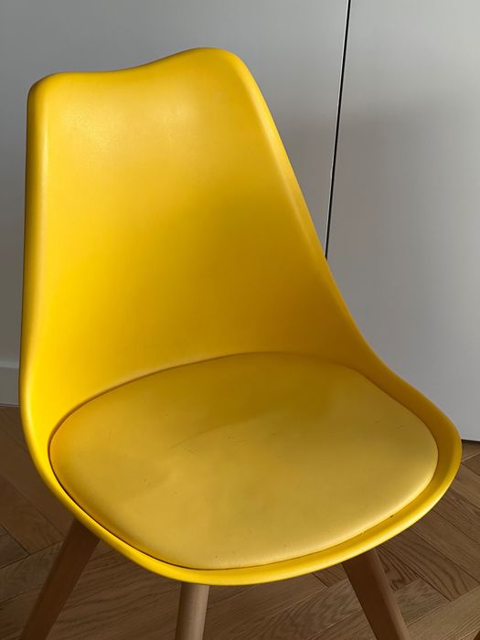 Dwa żółte krzesła na drewnianych nogach skandynawski styl