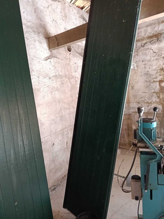 Portão seccionado vertical de pavilhão branco por dentro verde por fora com motor.