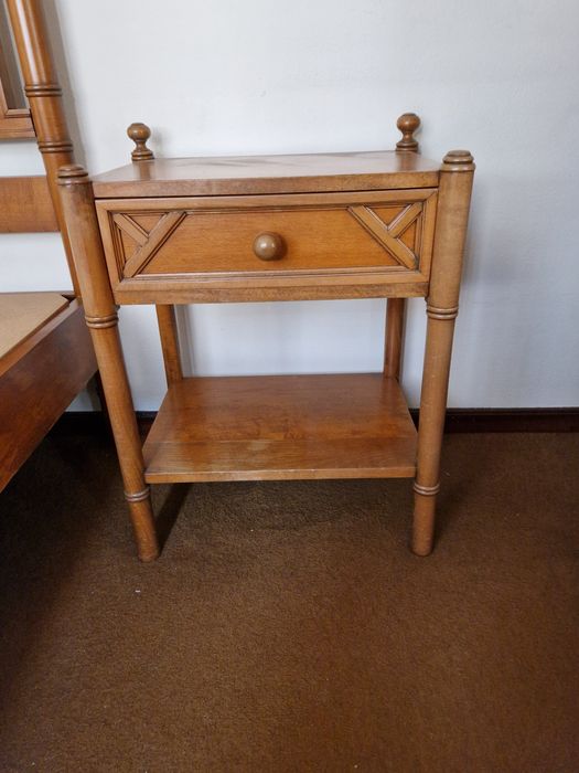 Uma cama de solteiro (2 por 1 metro) e uma mesa de cabeceira.