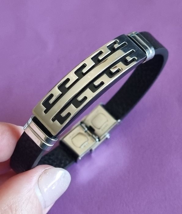 Pulseira de cabedal preto com peças prateadas em aço inoxidável.