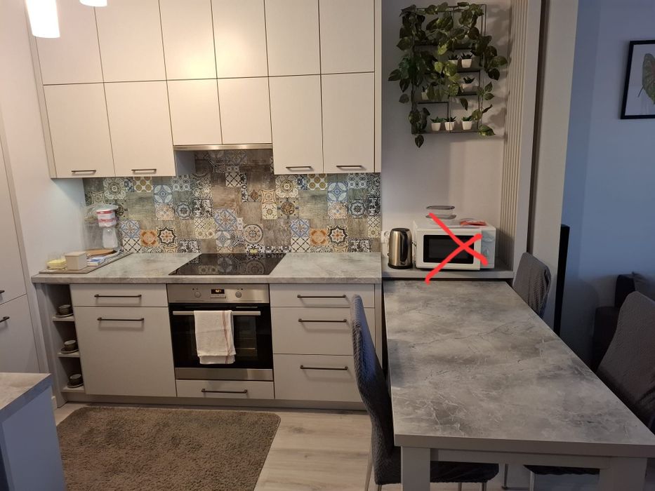 Zabudowa kuchenna ze stołem i sprzętem AGD