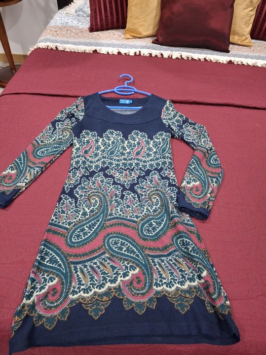 Vestido com um padrão floral e paisley vibrante.

- Decote redondo.
- Mangas compridas.
- Padrão paisley em azul, verde e rosa.