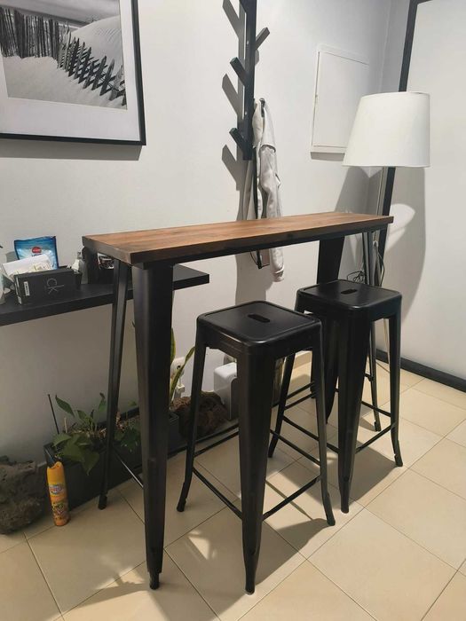Mesa alta com tampo de de madeira natural e duas cadeiras