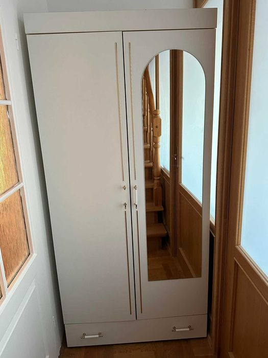 Sprzedam białą szafę ubraniową z lustrem i szufladą.