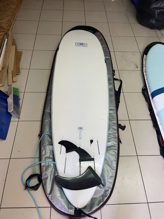 Prancha de surf Ocean & Earth Happy Hour Epoxy Softop 7.0 (52L) em bom estado geral, vendida com capa de proteção.