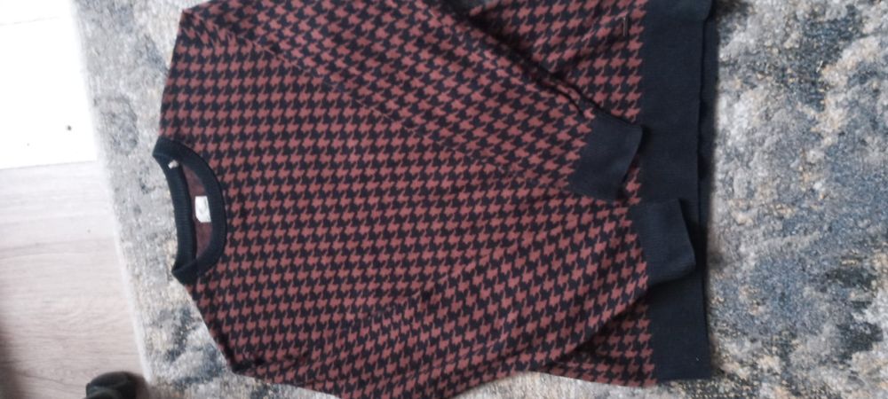 Bordowy sweter w czarną pepitkę.