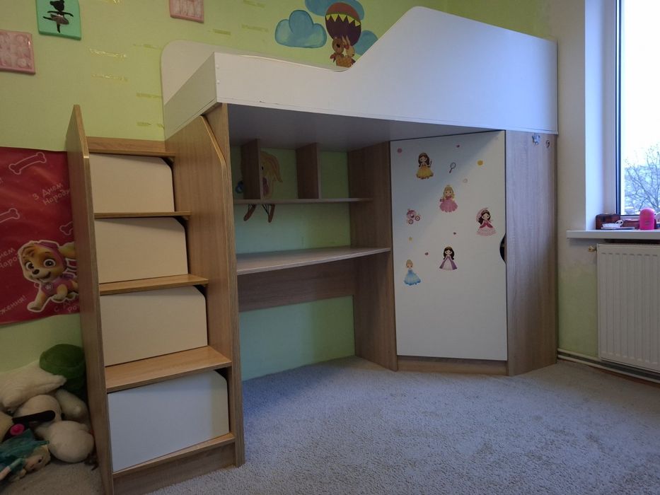 Двох ярусне ліжко, зі столом внизу.