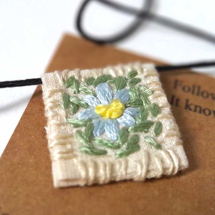 Pulseira bordada à mão com pingente de margarida branca