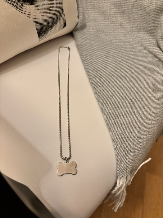 Fio prateado com pendente em forma de osso