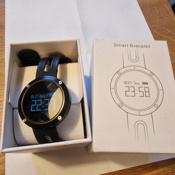 Smartwatch z paskiem i kablem do ładowania