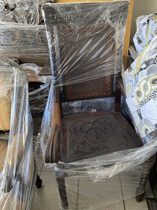 Escritório em Pau Santo, com mesa com tampo de vidro. Um cadeirão e duas cadeiras. Com móvel livros.