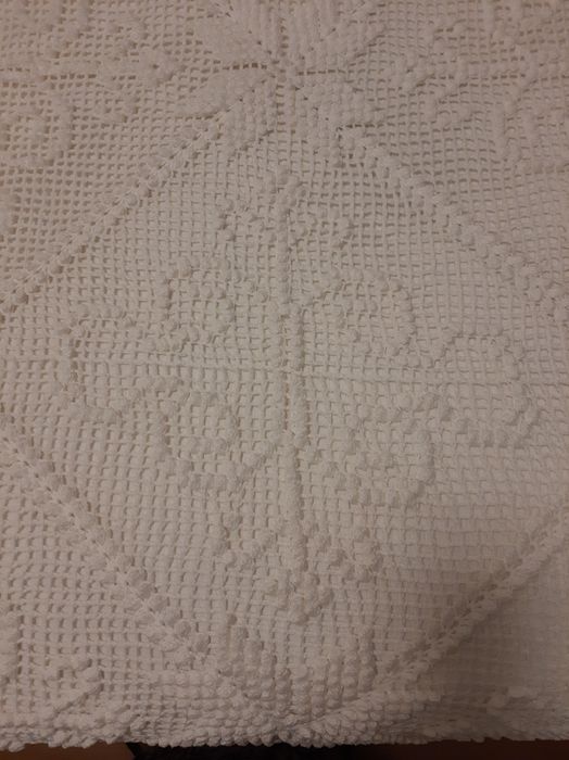 Colcha branca de renda feita à  mão .