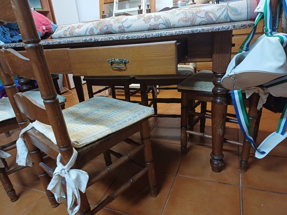 Mesa de cozinha com tampo em pedra, seis cadeiras e suas proteções