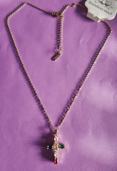 Colar dourado, em aço, com cruz colorida. Tem extensor.