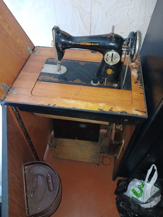 Швейная машинка с ножным приводом находится в тумбочке