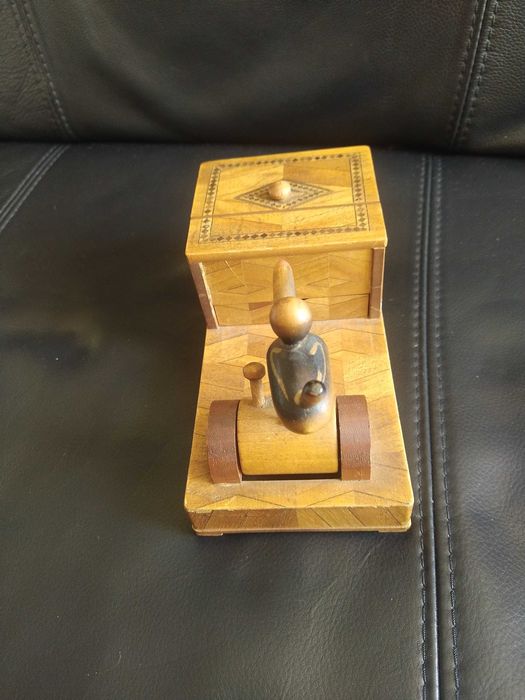 Antiga caixa artesanal, com movimento. Recolhe objetos movendo um peça