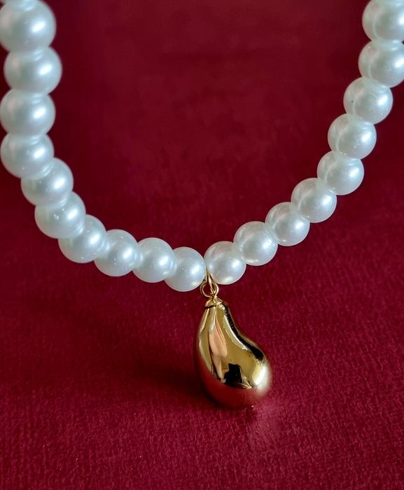 Colar de pérolas com acabamento e pingente em forma de gota, em aço.